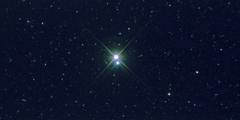 Der Doppelstern Albireo leuchtet gelb und blau. Um ihn herum sind viele Sterne als Punkte zu erkennen. Eine Anfänger-Aufnahme und daher nur von bescheidener Qualität.